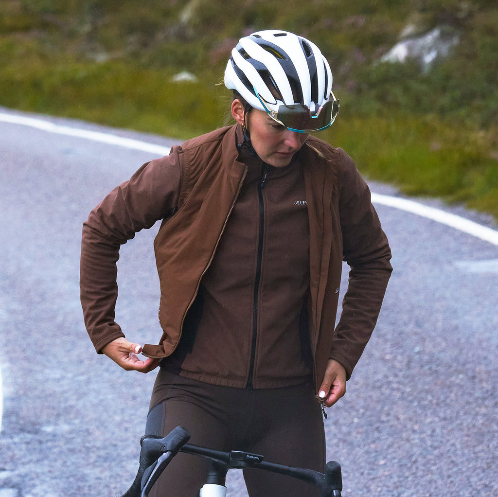 Cyclist wearing lightweight package cycling gilet on road with helmet and glasses