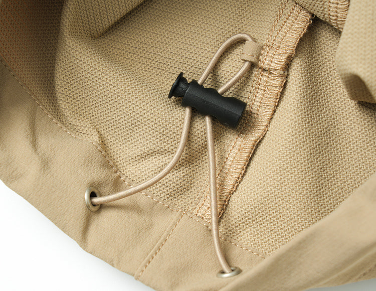 Close-up of beige drawstring cargo pants with adjustable cord and black toggle lock