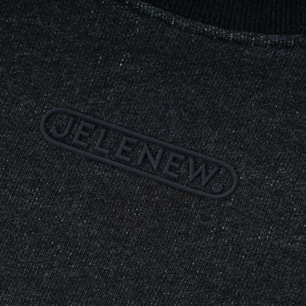 close-up of black Essentials Cotton Crewneck sweatshirt fabric with JELENEW logo detail