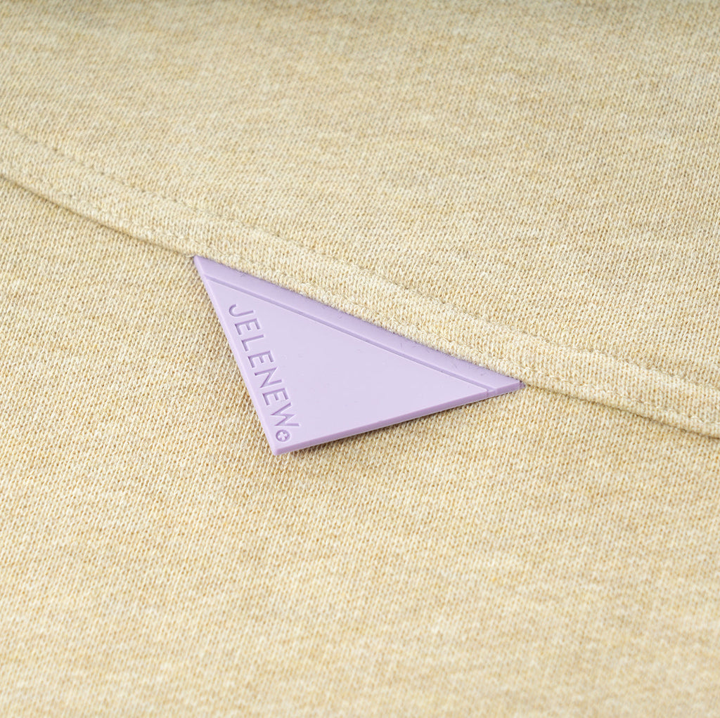 Close-up of beige Essentials Cotton Crewneck sweatshirt fabric with JELENEW logo tag