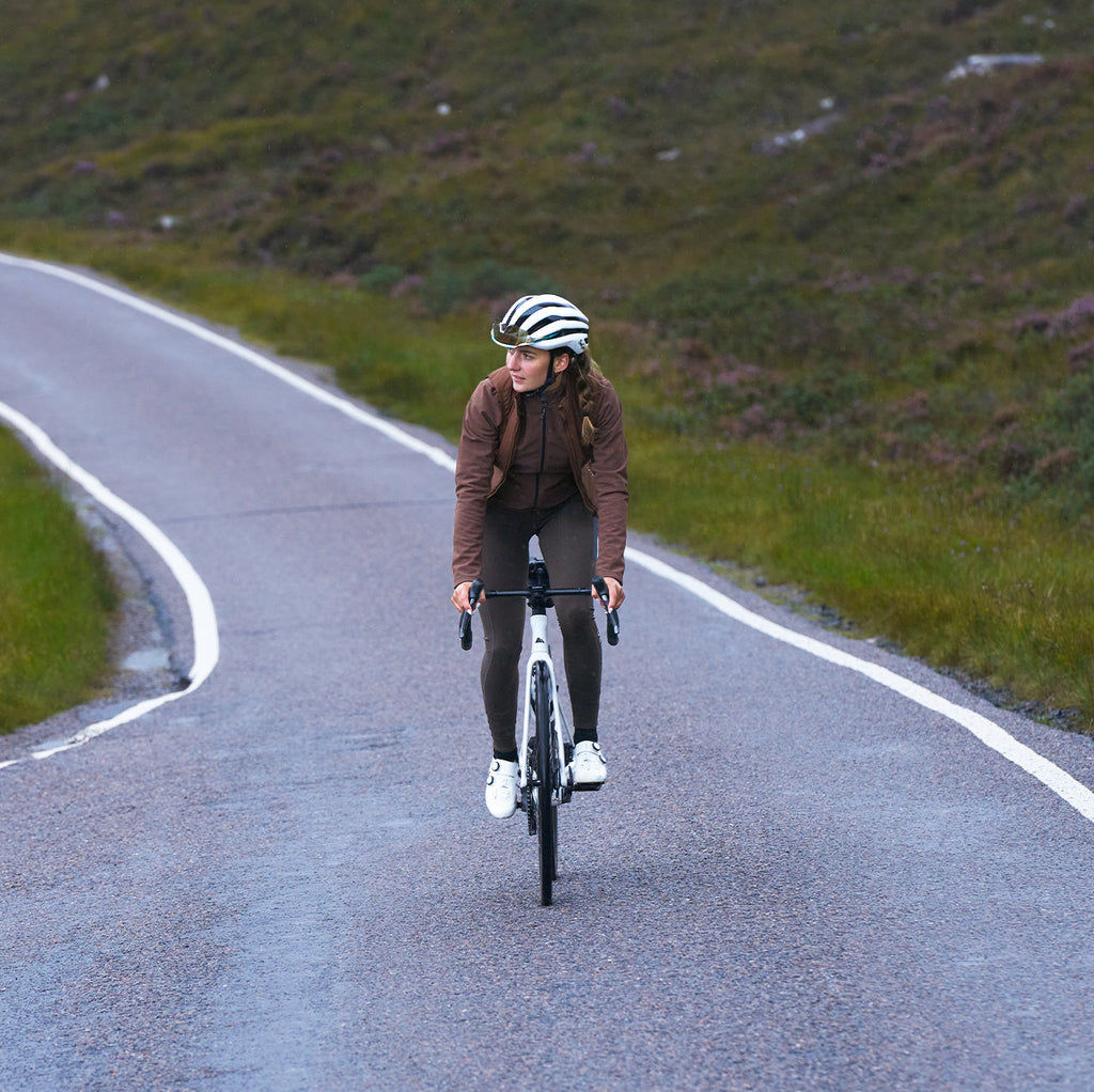 Cyclist wearing lightweight package cycling gilet riding on road in nature