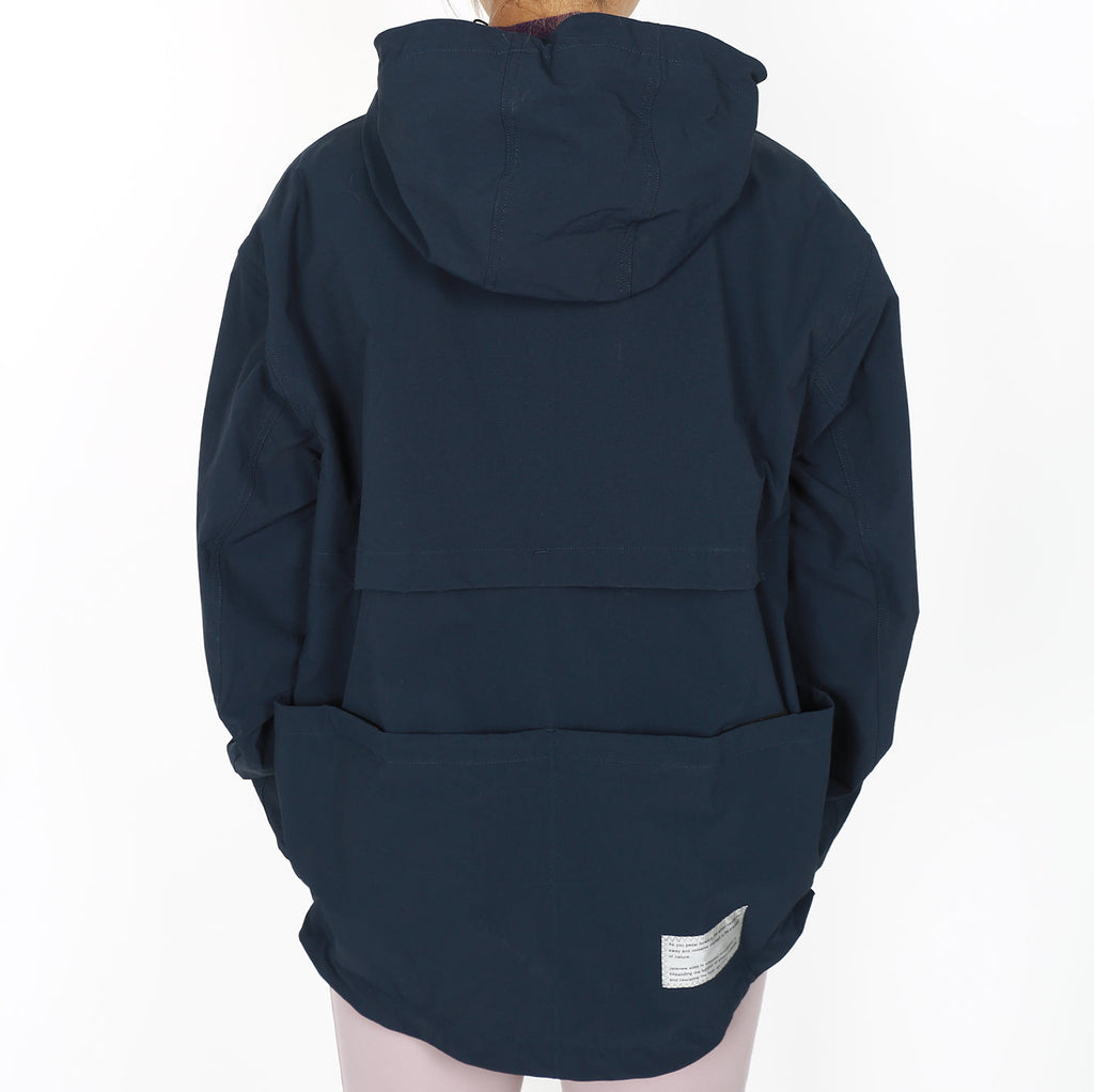 Back view of a navy blue half-zipped hooded jacket with weather-resistant fabric and storage pockets.