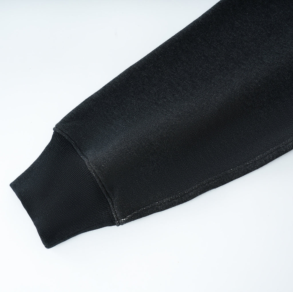 Close-up of black Essentials Cotton Crewneck sweatshirt sleeve with ribbed cuff